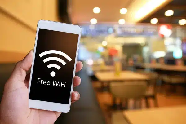 Man houd witte smartphone vast met wiffi teken erop