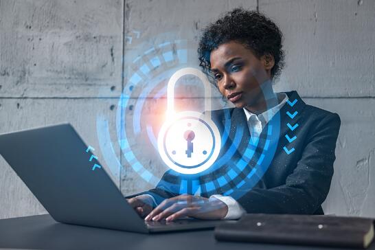 Vrouw achter laptop met hangslot op de voorgrond